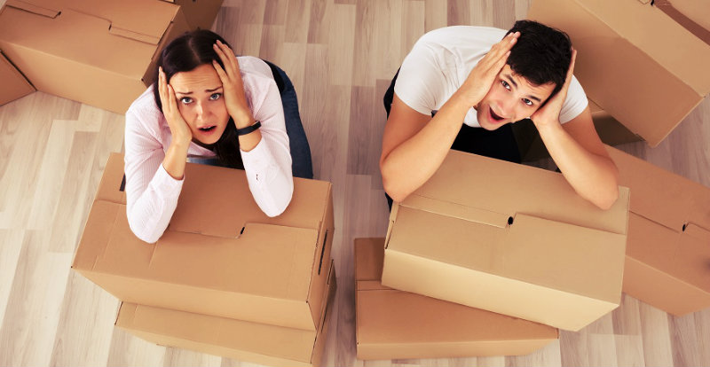 worried couple with cardboard boxes all around