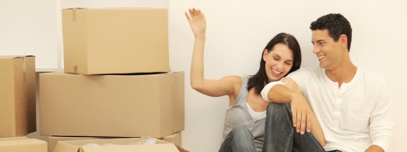 couple sitting on the floor with a couple of moving boxes