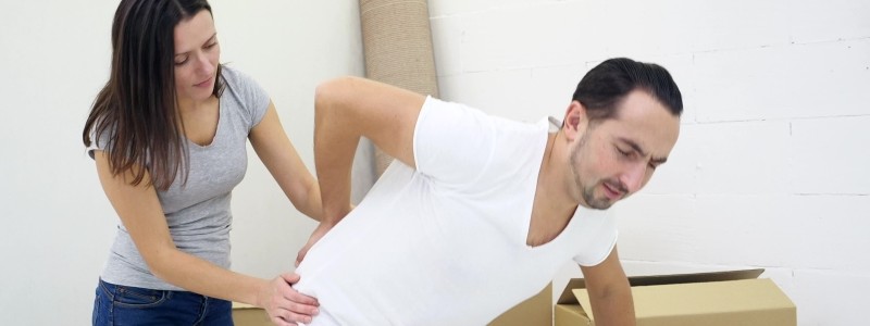 young man suffering from back pain during a household relocation