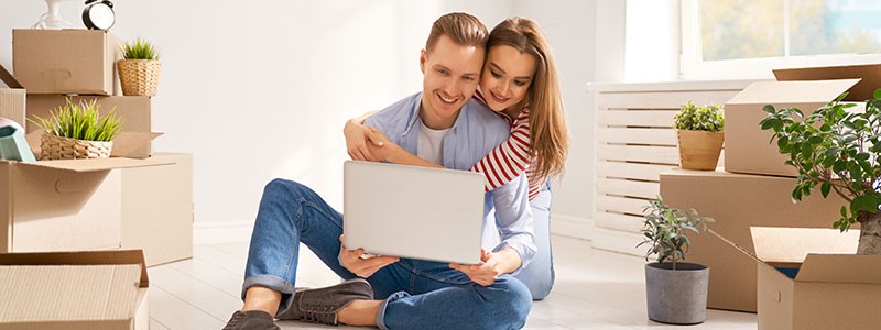 couple sitting on the floor with a laptop and searching for something