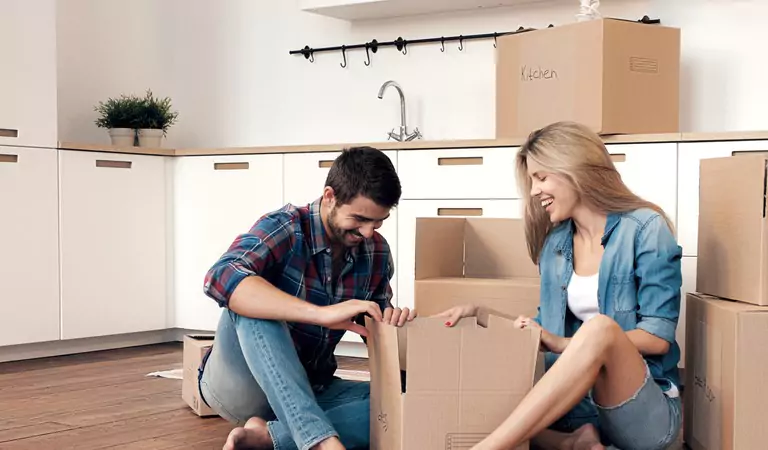 couple packing their belongings inside of a cardboard box