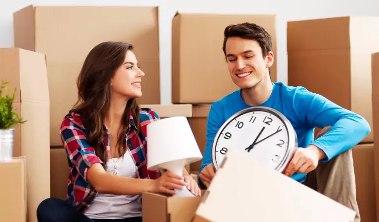 couple packing up a cardboard box while moving